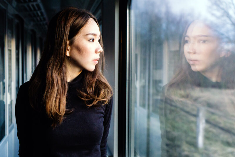 Woman looking at her reflection in a window.